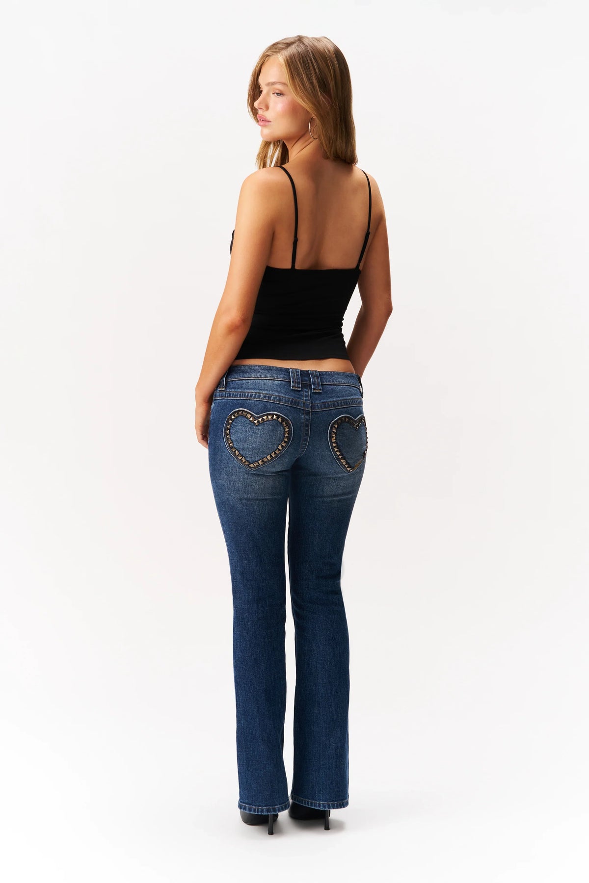 Model wearing Guizio Luli denim with heart shaped back pockets, back view