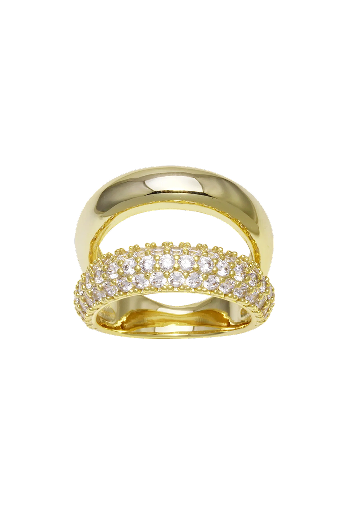A gold ring featuring a smooth, polished oval band layered behind a double row of pavé-set clear stones, shown on a plain white background.