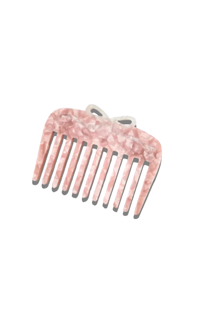A wide-tooth hair comb with a pink and white marbled tortoiseshell pattern and a small matching bow on top, shown against a plain white background.